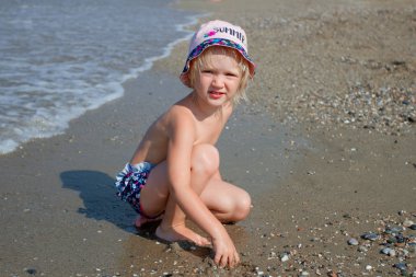 Sarışın bebek kız denize yakın oynayan yaz şapka