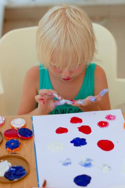 Pullar ile çizim boyalı elleri ile sevimli sarışın kız 