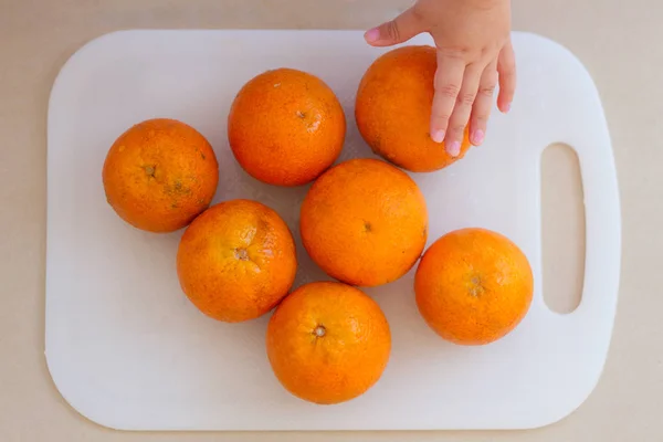 Main Enfant Sur Les Oranges Fraîches Agrumes Sur Planche Découper — Photo