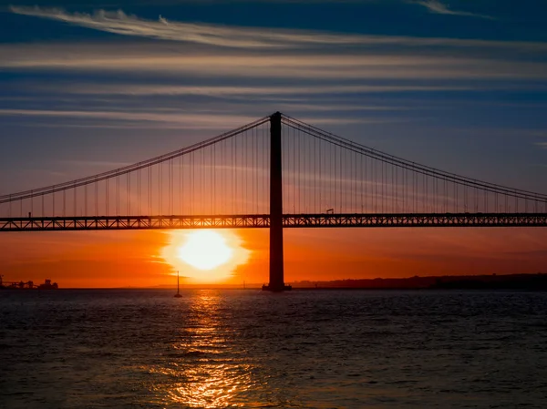 25. dubna most přes řeku Tejo. Západ slunce v Lisabonu. Slavný most v Lisabonu Royalty Free Stock Obrázky