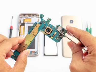 Teknisyen holdinging smartphone mantık kurulu ve mikro işlemci üzerinde sıkma Close-up smartphone bileşeni arka plan bulanık