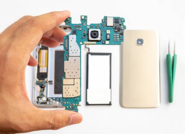 Teknisyen holdinging smartphone mantık boardon Close-up smartphone bileşen adam bulanık