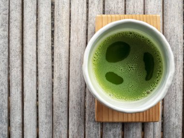 Organik yeşil çay matcha yüz beyaz Japon tarzı seramik kase töreni işlendikten sonra kopya alanı gülümseyen gibi köpük ile üstten görünüm