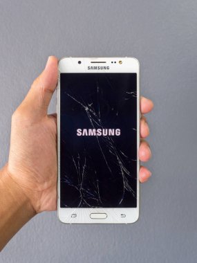 Chiangrai, Tayland: 22 Ekim 2017 - insan eli kırık smartphone Samsung Galaxy J5 2016 (Sm-J510fn) akıllı telefon hizmeti dükkanda holding
