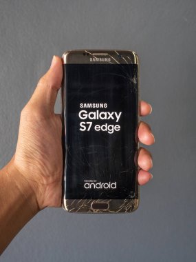 Chiangrai, Tayland: 4 Aralık 2018 - kırık smartphone tutarak ve metin 'Samsung Galaxy S7 edge' ve 'android' ekranda gösteren insan eli
