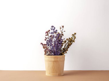 Buket grup kurutulmuş ve kahverengi zemin ve beyaz arka plan üzerinde ahşap kova birden fazla renk Gypsophila çiçekler solgunluk