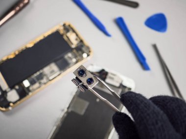 Teknisyen ya da kırık ikili smartphone kamera üzerinde gösterilen mühendis smartphone bileşenleri adam bulanık