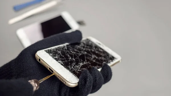 Technician or engineer opening broken smartphone for repair or replace new part on desk with copy space