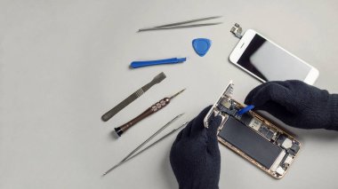 Teknisyen ya da bileşenleri kırık smartphone için sökülmesi mühendis tamir veya kopya alanı ile masa üzerinde yeni bölümü değiştirme