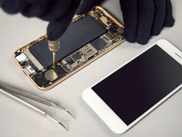 Technician or engineer disassembling components broken smartphone for repair or replace new part on desk