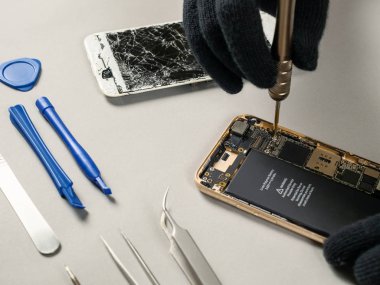 Teknisyen ya da bileşenleri kırık smartphone için sökülmesi mühendis tamir veya masa üzerine yeni bölümü değiştirme
