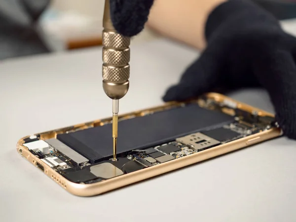 Técnico de reparación de teléfonos inteligentes rotos en el escritorio —  Fotos de Stock