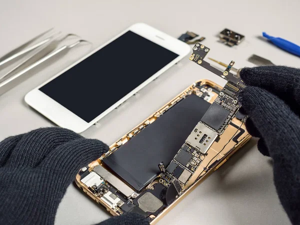 Técnico de reparación de teléfonos inteligentes rotos en el escritorio — Foto de Stock