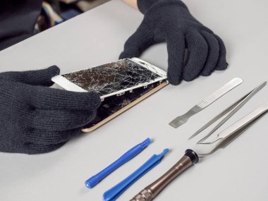 Masa üzerinde kırık akıllı telefon tamir teknisyeni