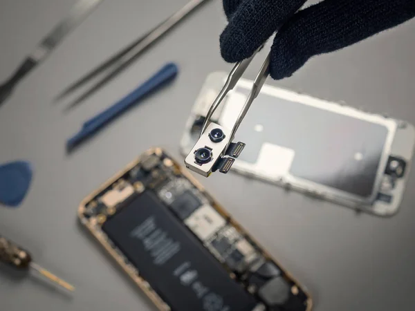 Técnico de reparación de teléfonos inteligentes rotos en el escritorio — Foto de Stock