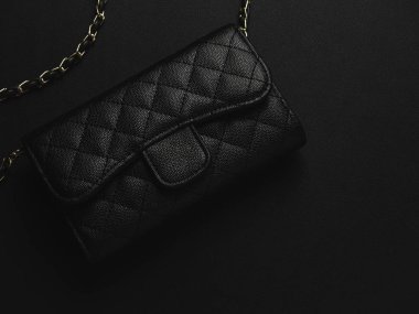 Altın zincirli siyah deri çanta.