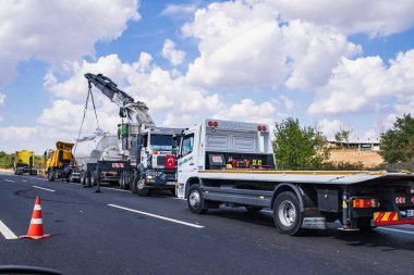 İstanbul yakınlarındaki otoyolda meydana gelen trafik kazası sonrasında ağır hasar görmüş sarı bir kamyonun acil kurtarma operasyonu. Bir vinç ve işçiler enkazı kaldırıyor. Türkiye, İstanbul - 9 Eylül 2025