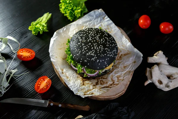 Siyah bir arka plan üzerinde bir peçete üzerinde siyah burger