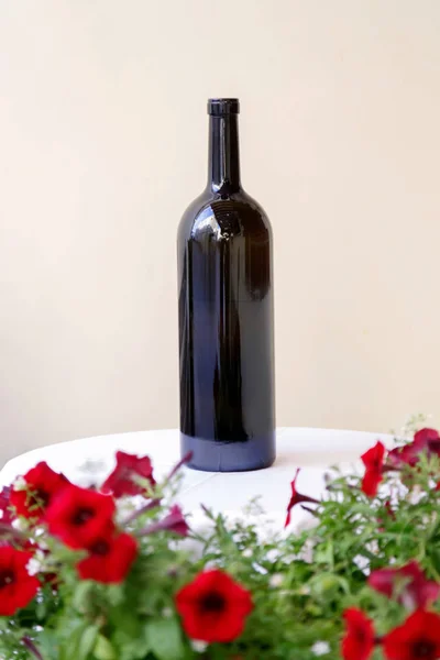 桌上的一瓶葡萄酒 桌上铺着鲜花的白色桌布 — 图库照片