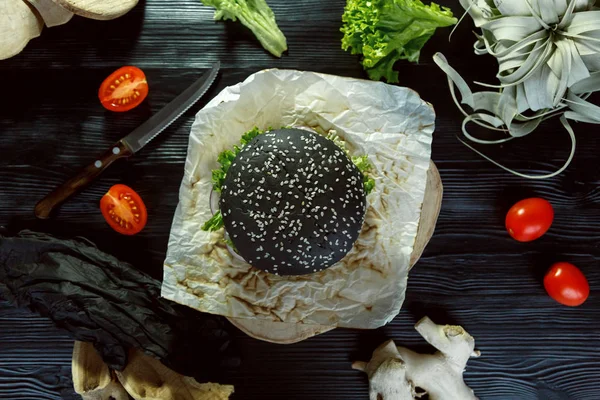 Hamburguesa Negra Sobre Una Servilleta Sobre Fondo Negro — Foto de Stock