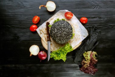 Domatesli siyah burger, Çin lahanası, siyah ahşap arka plan üzerine soğan