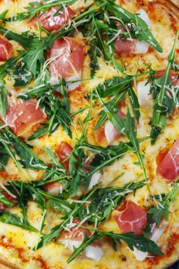 Siyah ahşap arka plan üzerinde pastırma, peynir ve otlar ile Pizza