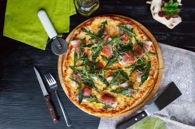 Siyah ahşap arka plan üzerinde pastırma, peynir ve otlar ile Pizza