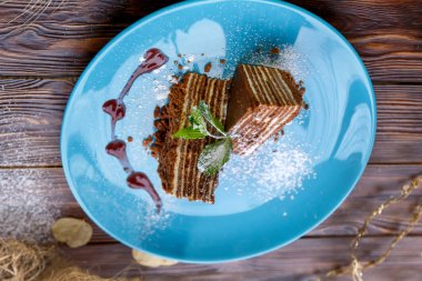 Kahverengi ahşap arka plan üzerinde mavi bir tabak üzerinde kek Dilimleri