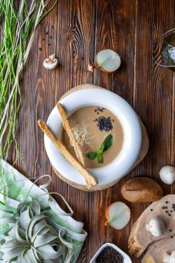 Kahverengi ahşap arka plan üzerinde champignons ve otlar ile makarna ile Mantar çorbası