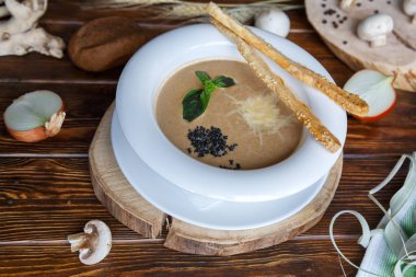 Kahverengi ahşap arka plan üzerinde champignons ve otlar ile makarna ile Mantar çorbası