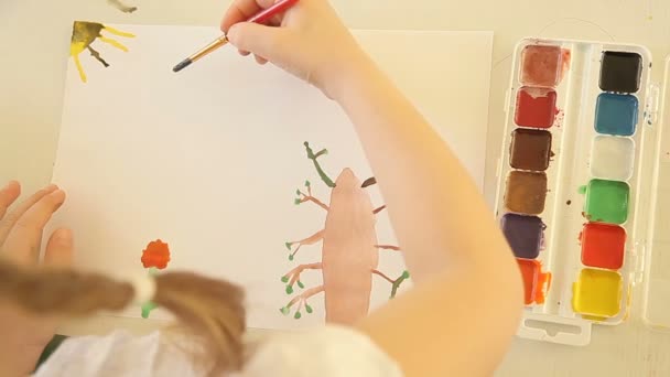 Het meisje schildert een blauwe wolk met een penseel en verf — Stockvideo