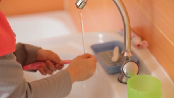 Der Junge schließt den Wasserhahn mit Wasser — Stockvideo