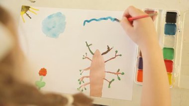 Kız bir fırça ve boya mavi bir bulutla boyalar