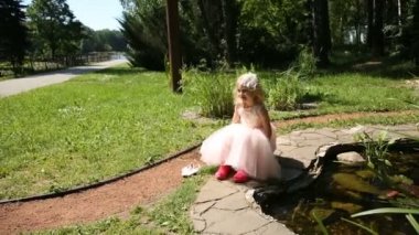 Lastik çizmeler bir çiçek bahçesinde, küçük kız