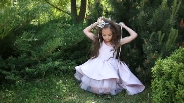 Een klein meisje is het dragen van kralen rond haar nek — Stockvideo