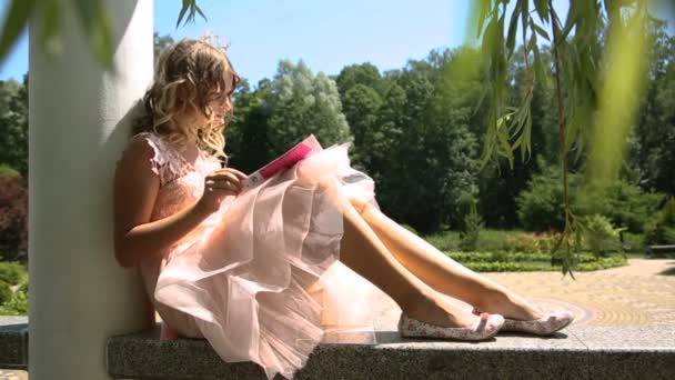小女孩在公园里看书 — 图库视频影像