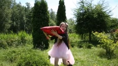 Küçük kız bir yastığı atar