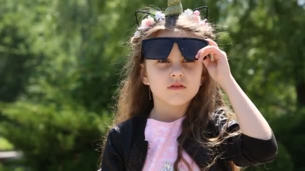 Mała dziewczynka zdejmuje okulary przeciwsłoneczne — Wideo stockowe