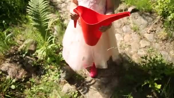 小女孩用红色浇灌罐头 — 图库视频影像