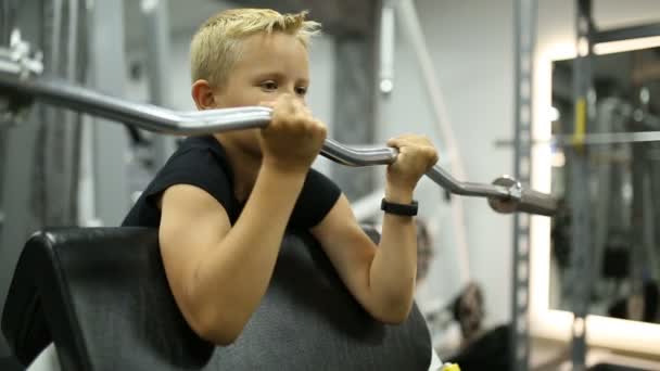 Pojken i gymmet lyfter baren — Stockvideo