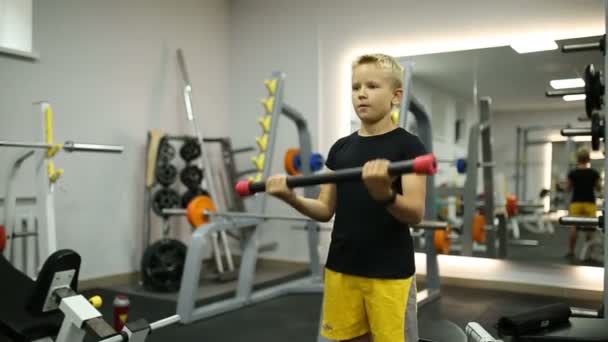 De jongen in de sportschool is sporten — Stockvideo