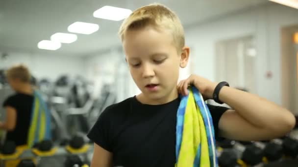 The boy at the gym is drinking water — Stock Video