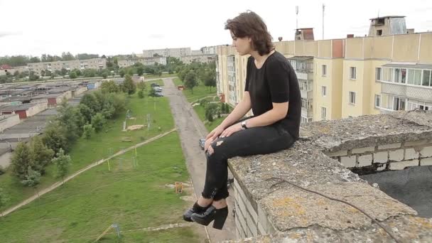 Teen girl sitting on the edge of the roof — Stock Video