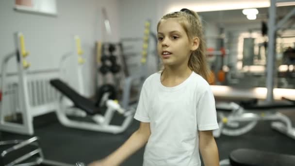 Chica con mancuernas en el gimnasio — Vídeo de stock