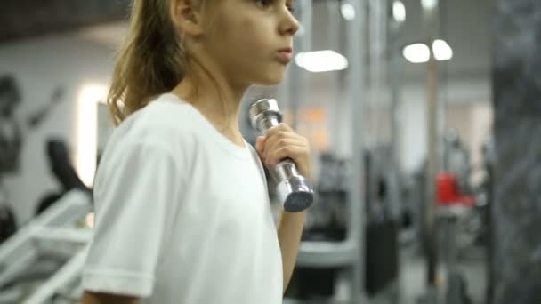 Little girl in the gym engaged with dumbbells — Stock Video