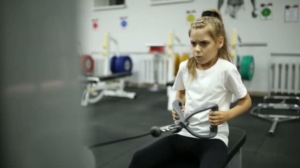 Ребенок в спортзале тренируется на тренажере — стоковое видео