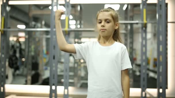 Una niña en el gimnasio está contenta con el entrenamiento. — Vídeos de Stock