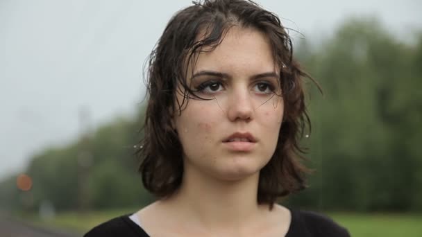 Девушка-подросток, стоящая под дождем — стоковое видео