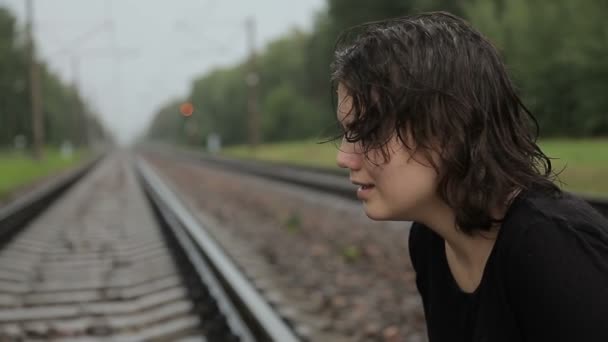 Teen flicka gråter på järnvägsspåren — Stockvideo