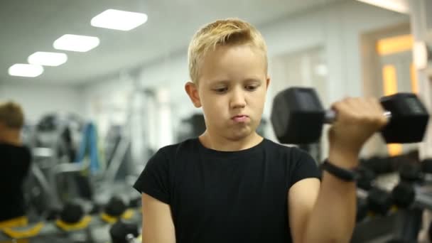 The boy is training muscles in the gym — Stock Video